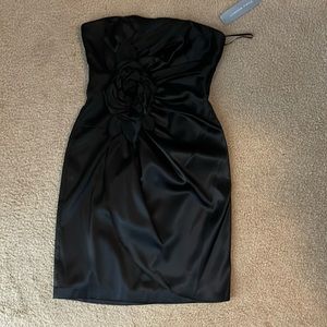 Strapless black cocktail dress with large black flower.